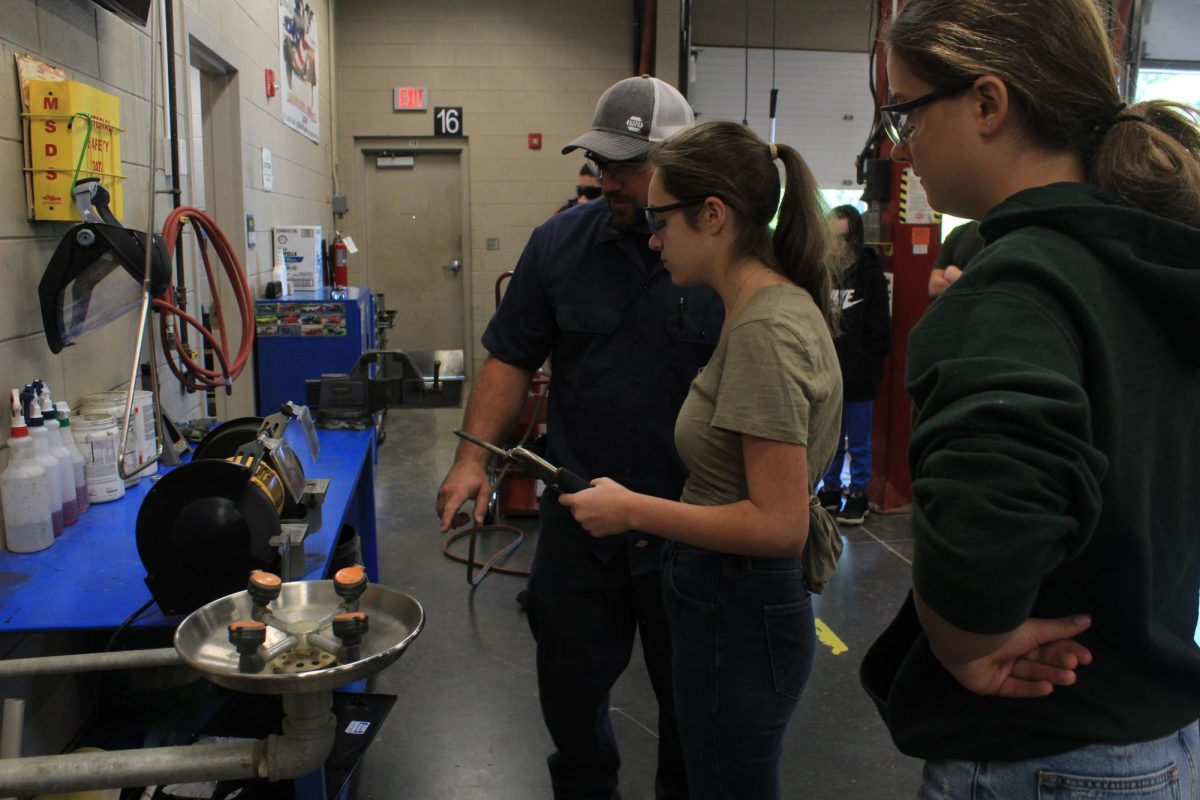 Mr. Galanti teaches students how to use a grinder.
