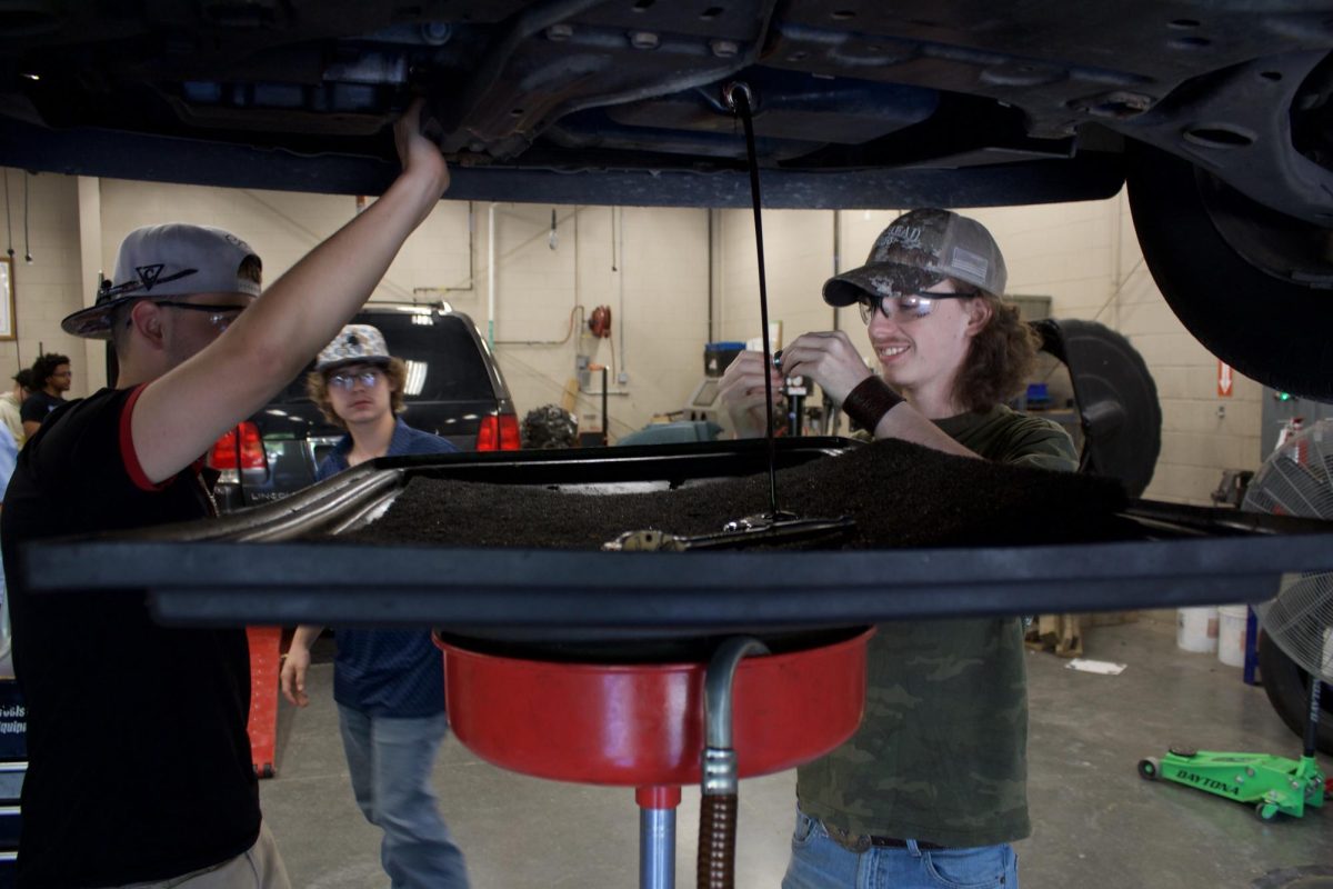 Auto 2 students check the gasket on an oil drain plug.