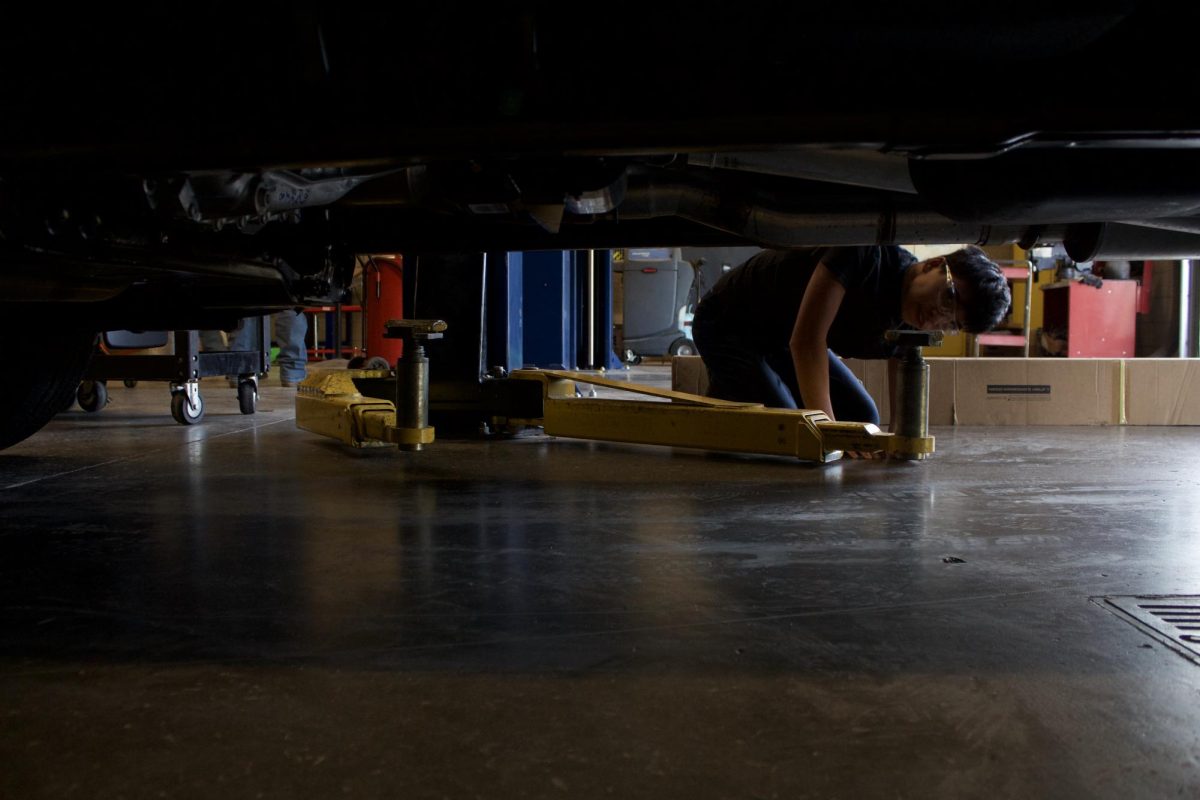 An Auto 2 student works on setting the rack on a truck.