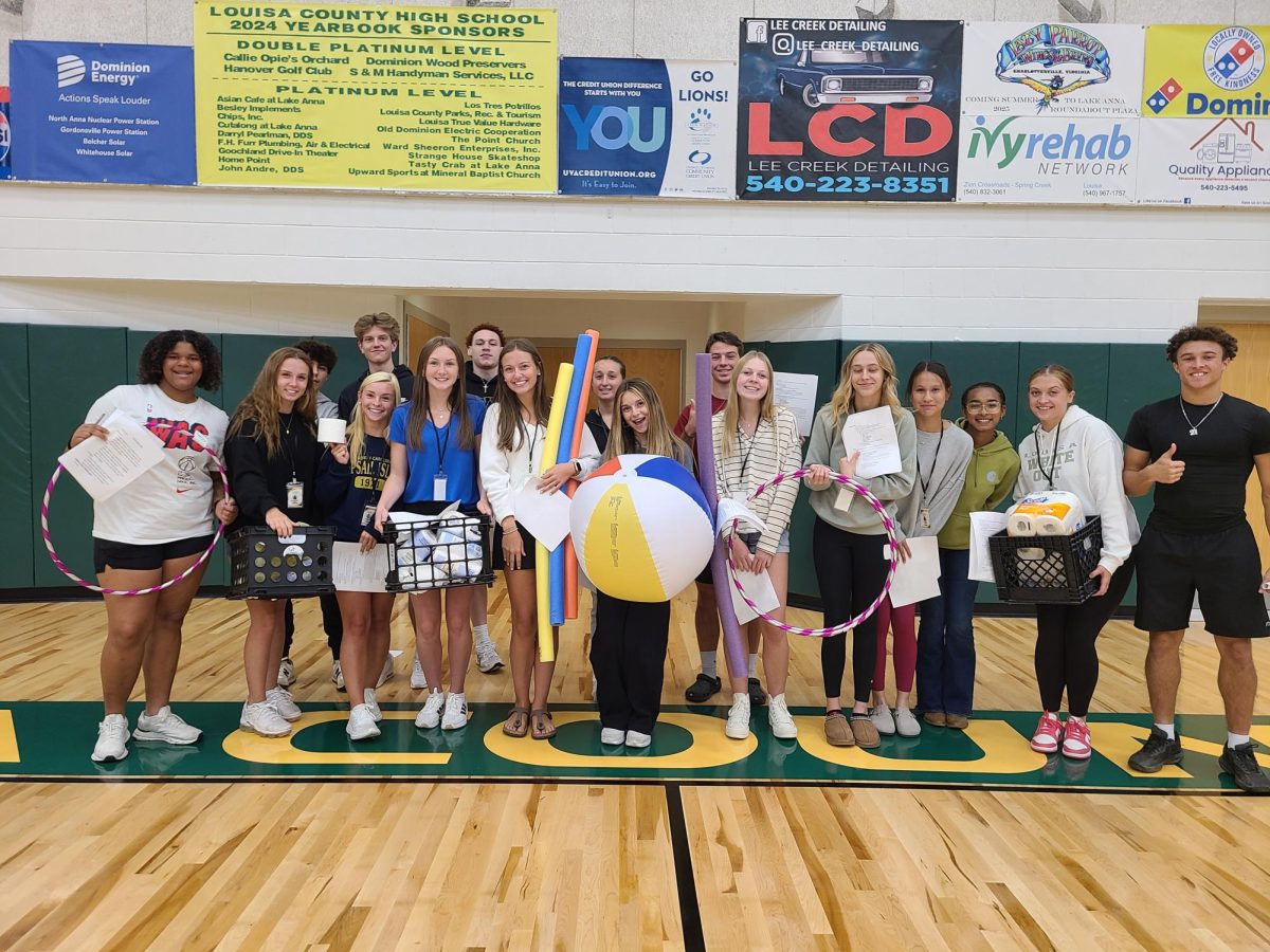 Leadership practicing for the pep rally, holding props for the games.