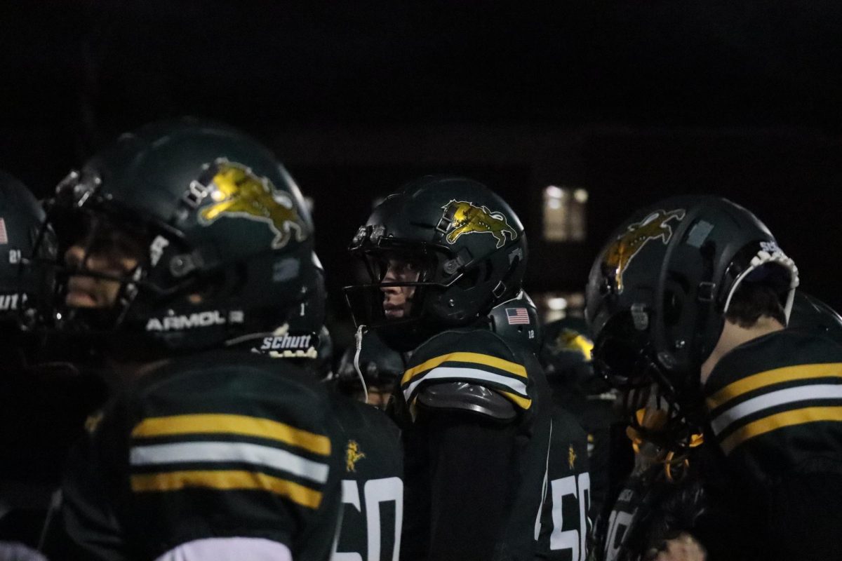 Senior Gavin Anderson and his teammates watch the plays from the sidelines.