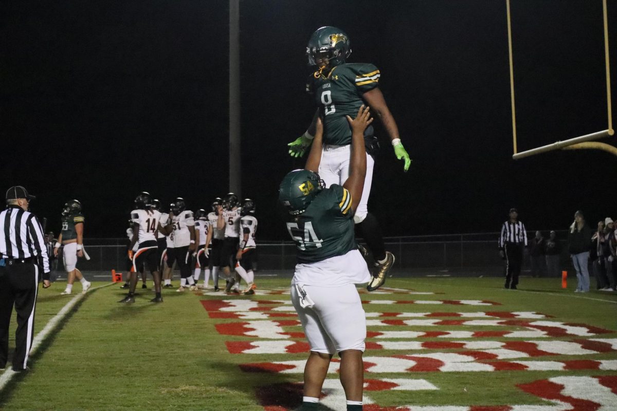 After a touchdown, Junior Jahmere Ragland lifts up running back Lavartrell Creasy.