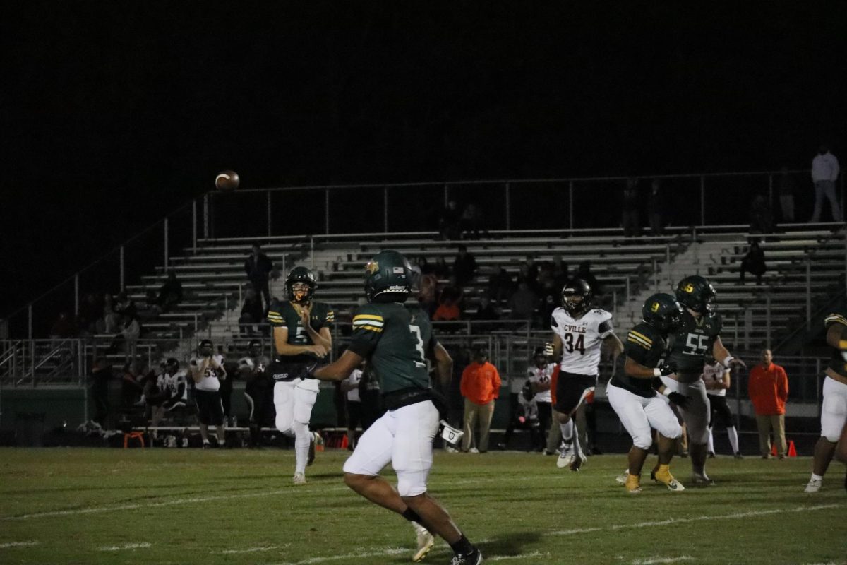 Quarterback Caleb Brady passes the ball to running back Dustin Nelson. 