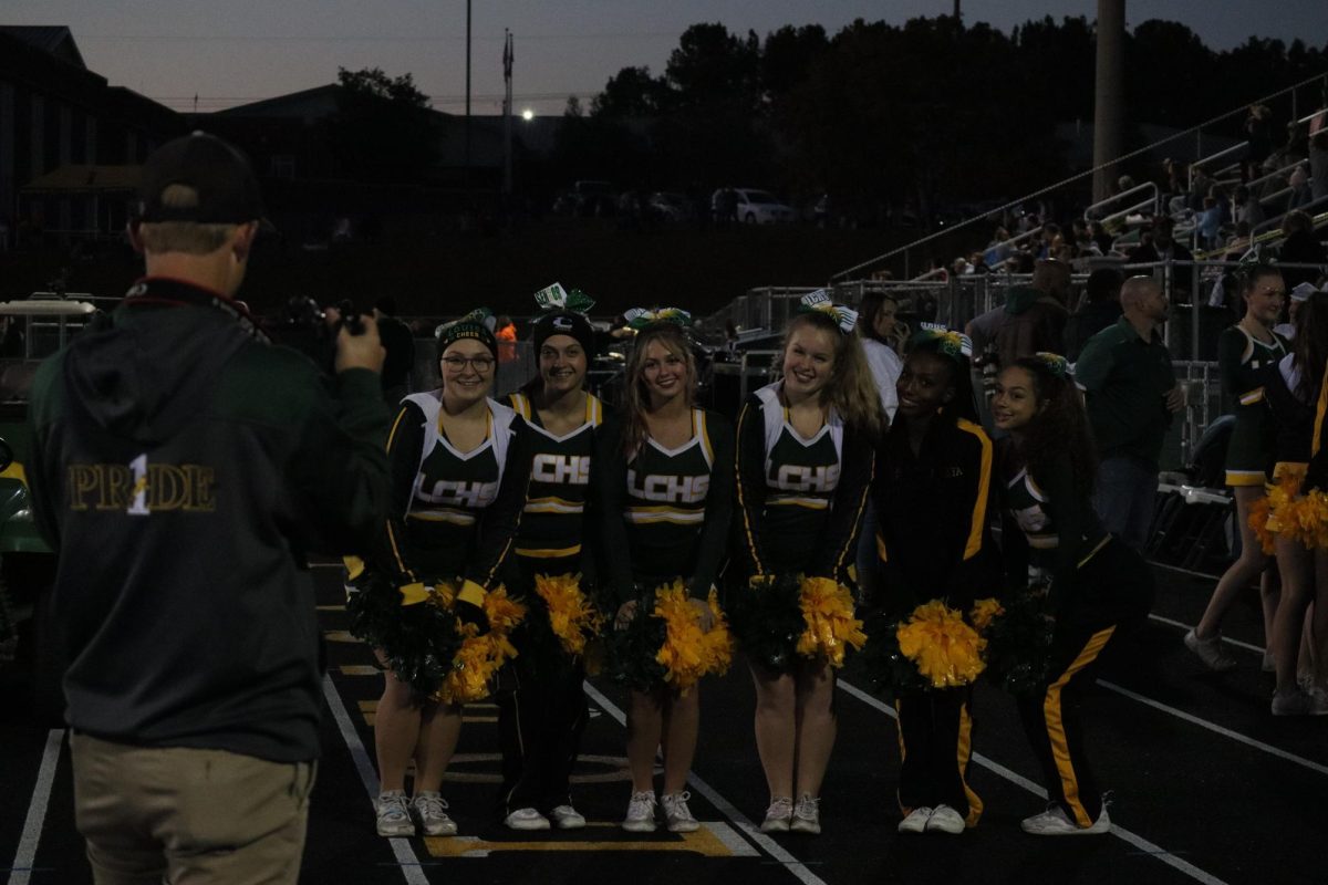 Public relations officer Andrew Woolfolk takes a picture of the Varsity cheer team. 