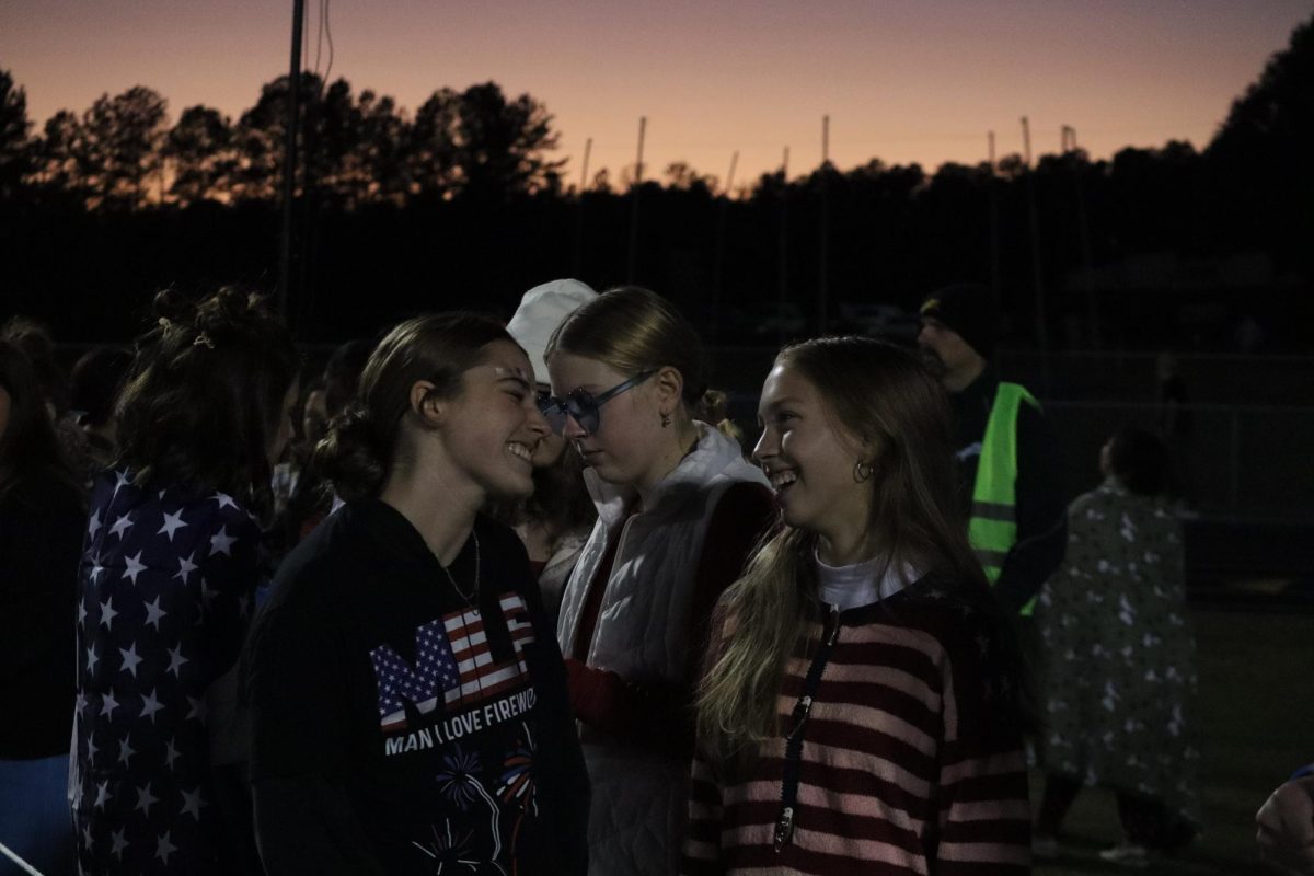 Juniors Brooke Pennella and Aubrie Sherry laugh together in the student section. 