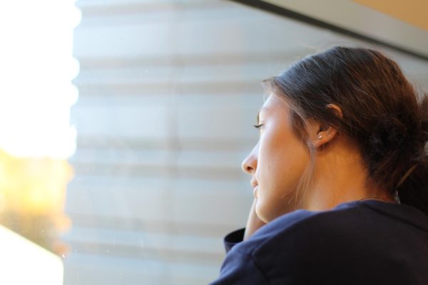 Junior Lauren Goodman looking out the school window thinking of her family.