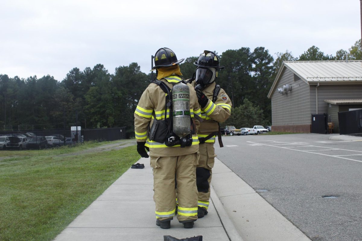 Fire and EMS students check each other to make sure their equipment is secured properly.