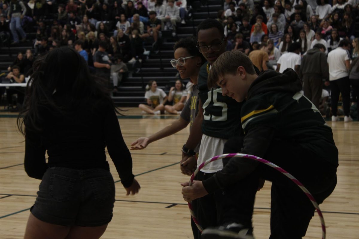 Juniors Robin Hache, Jerrick Carter, and Erica Timberlake participate in the hula hoop chain pep rally game.