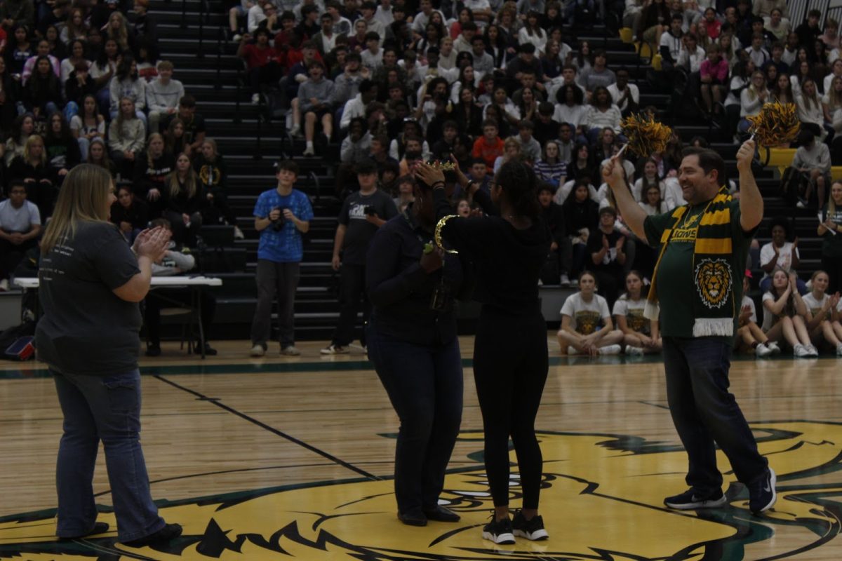 Tammy Brown is crowned staff homecoming queen by a leadership student.