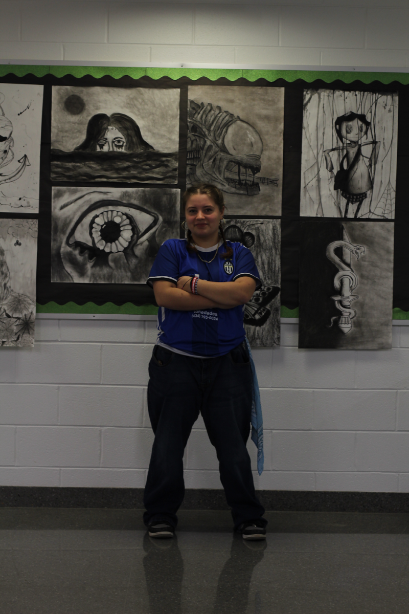 Scarlett Dogget Ayala poses in front of students' artworks while showing her Y2K outfit inspired by Dilemma by Kelly Rowland and Nelly.