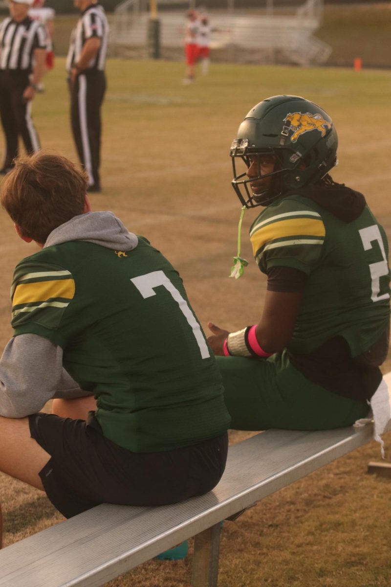 Players Zaveian Harris and Holden Pekary having a conversation on the bench during the game.