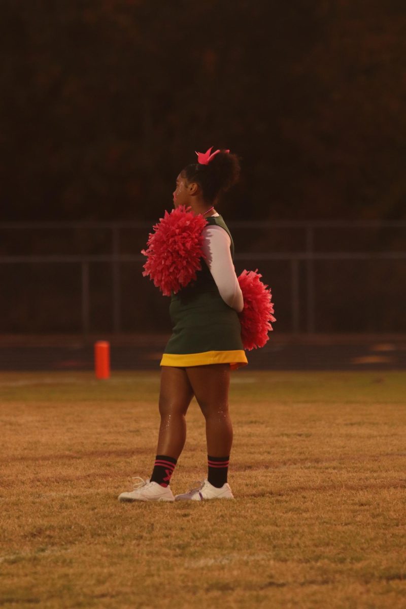 JV Cheerleader Name standing for the national anthem before the game