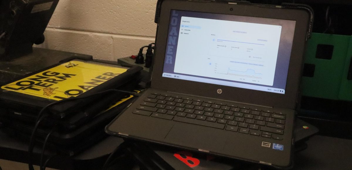 A stack of loaner Chromebooks at the TAC desk, with one opened to the diagnostics menu. 
