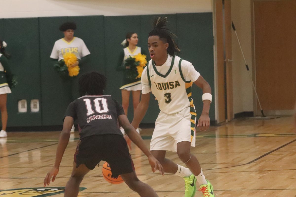 Sophomore guard Johaun Ellis dribbles past his defender in the middle of the court.