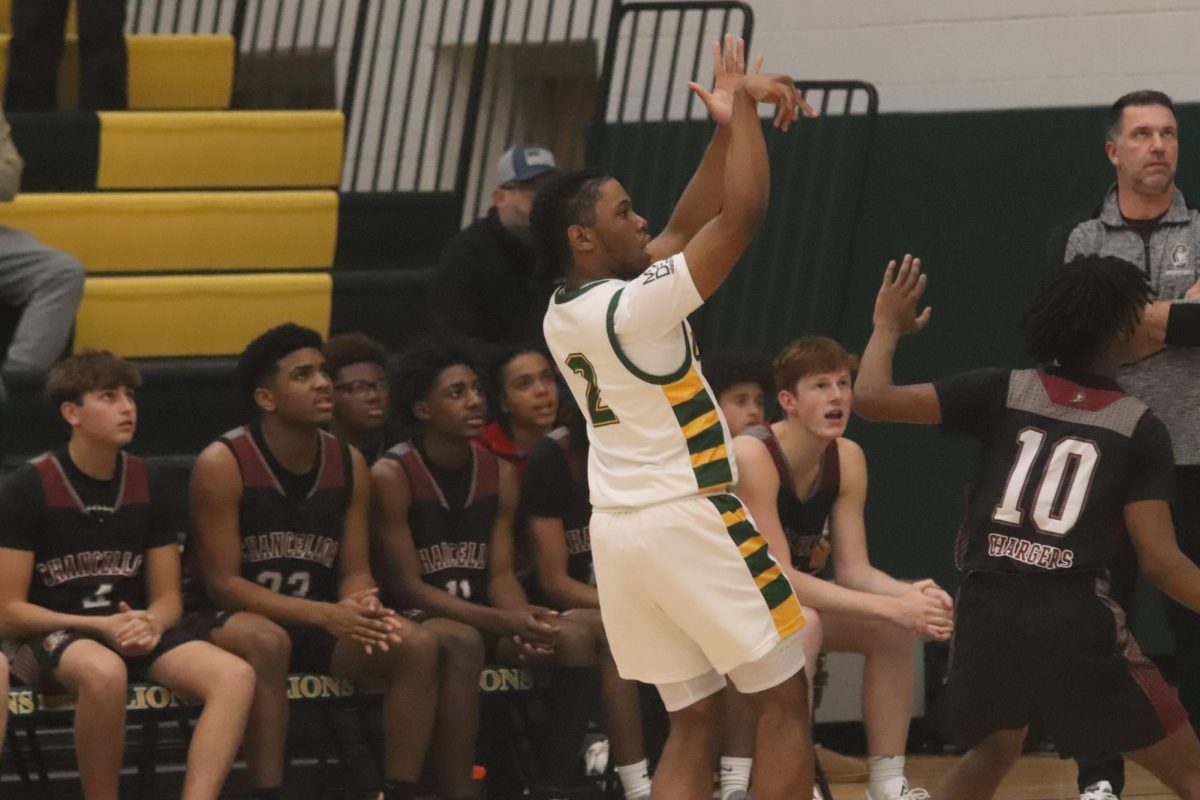 Senior guard Raesaun Ellis holds his shot form after he shoots the ball for three with the defender in his face.