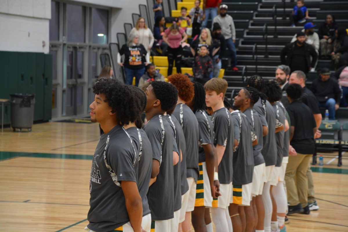 The team convenes during the national anthem before their game against the Goochland Bulldogs.
