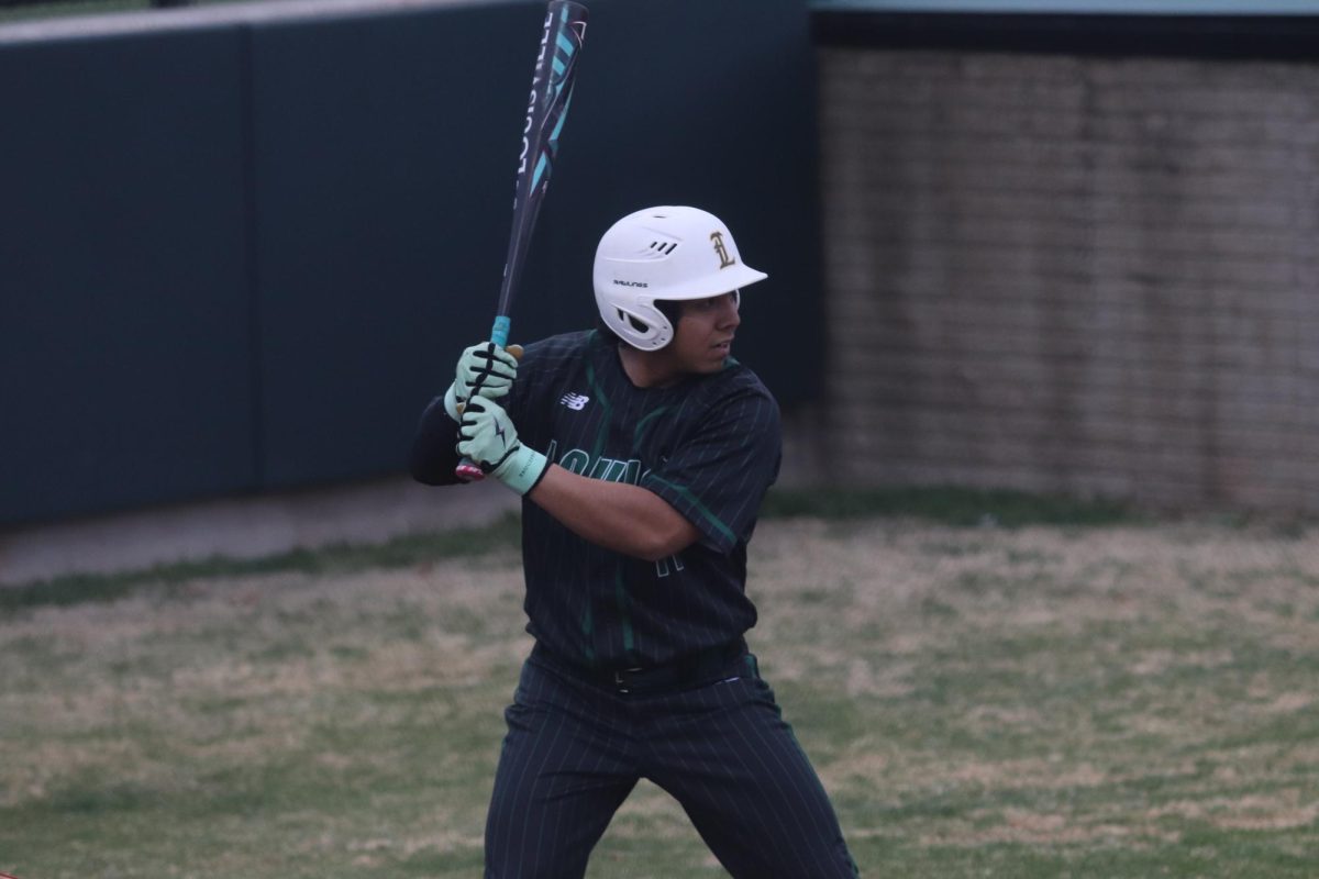 Senior Ian Taylor preparing to swing at a baseball game.
