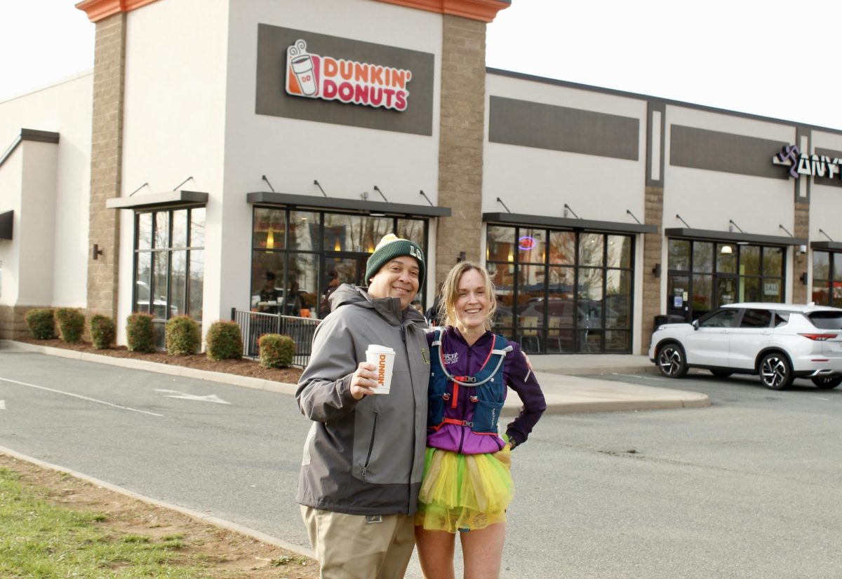 Principal Rodney Redd greets Fletcher after she arrives at Dunkin’ Donuts. 