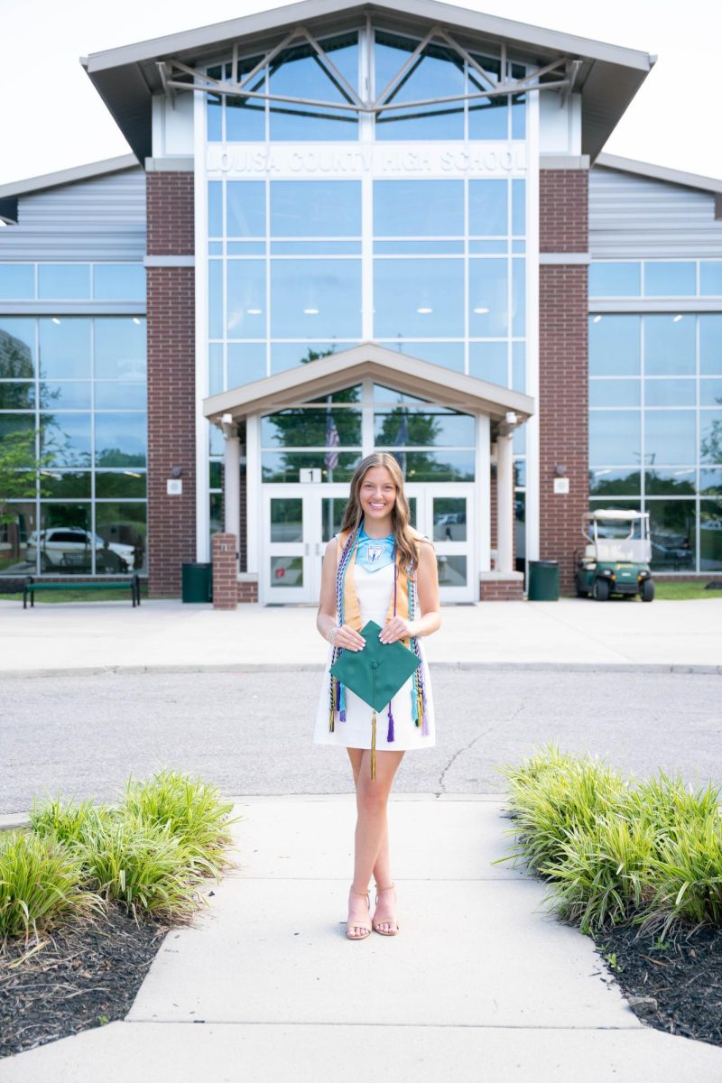 Cassie Duerson stands in front of the main entrance to the high school. 