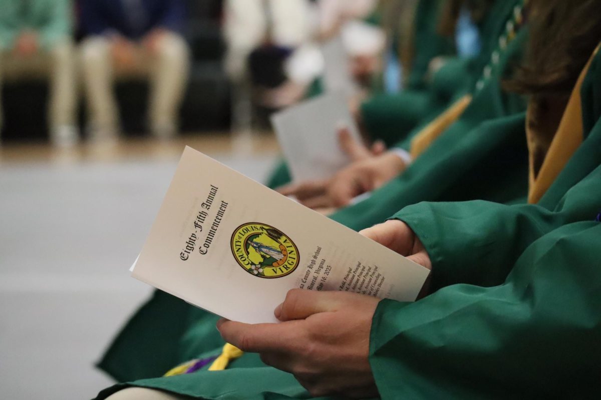 The graduate looks through the eighty-fifth annual commencement ceremony program.
