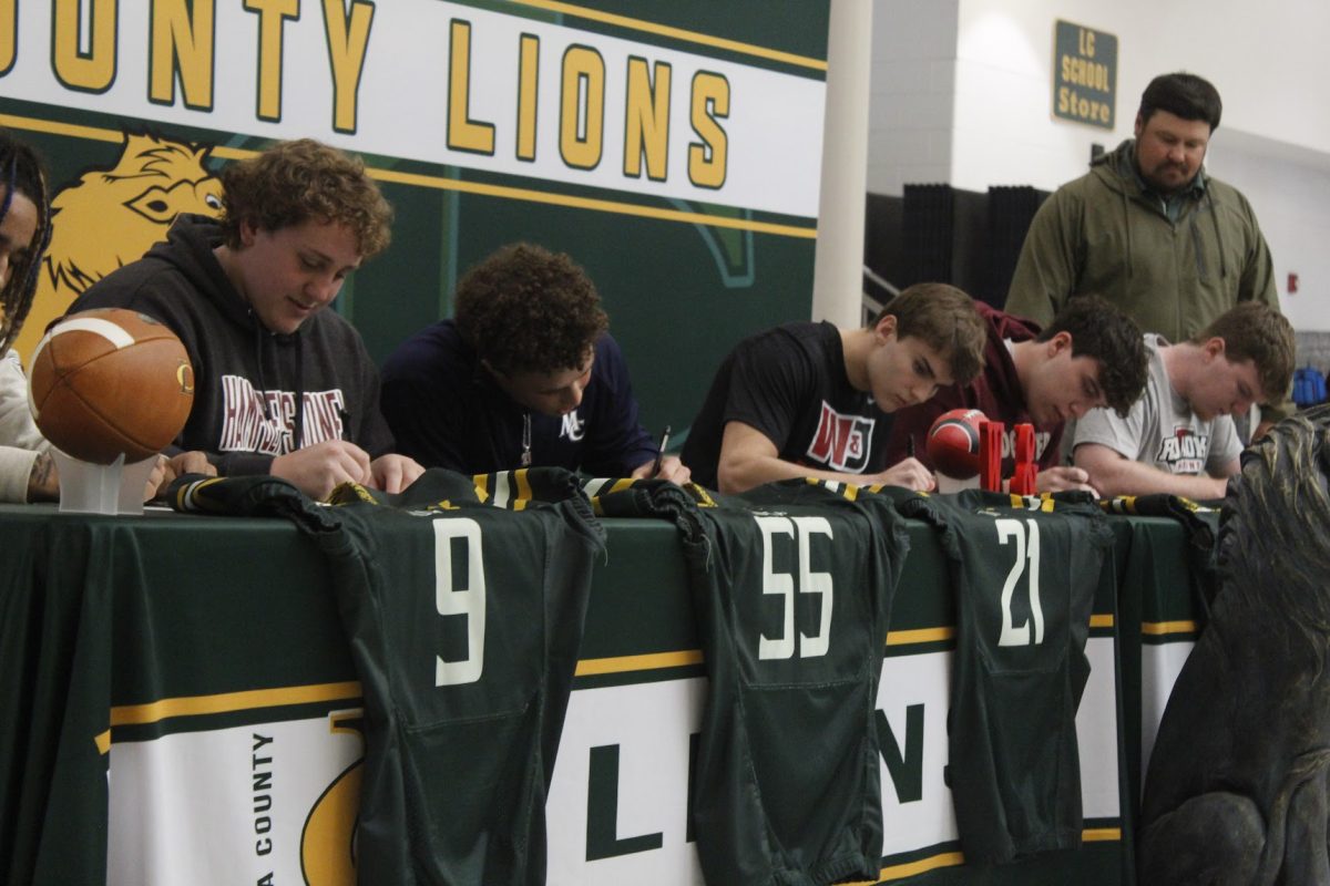 Senior football players on signing day commiting to the schools that they will take their future steps in their athletic career. 