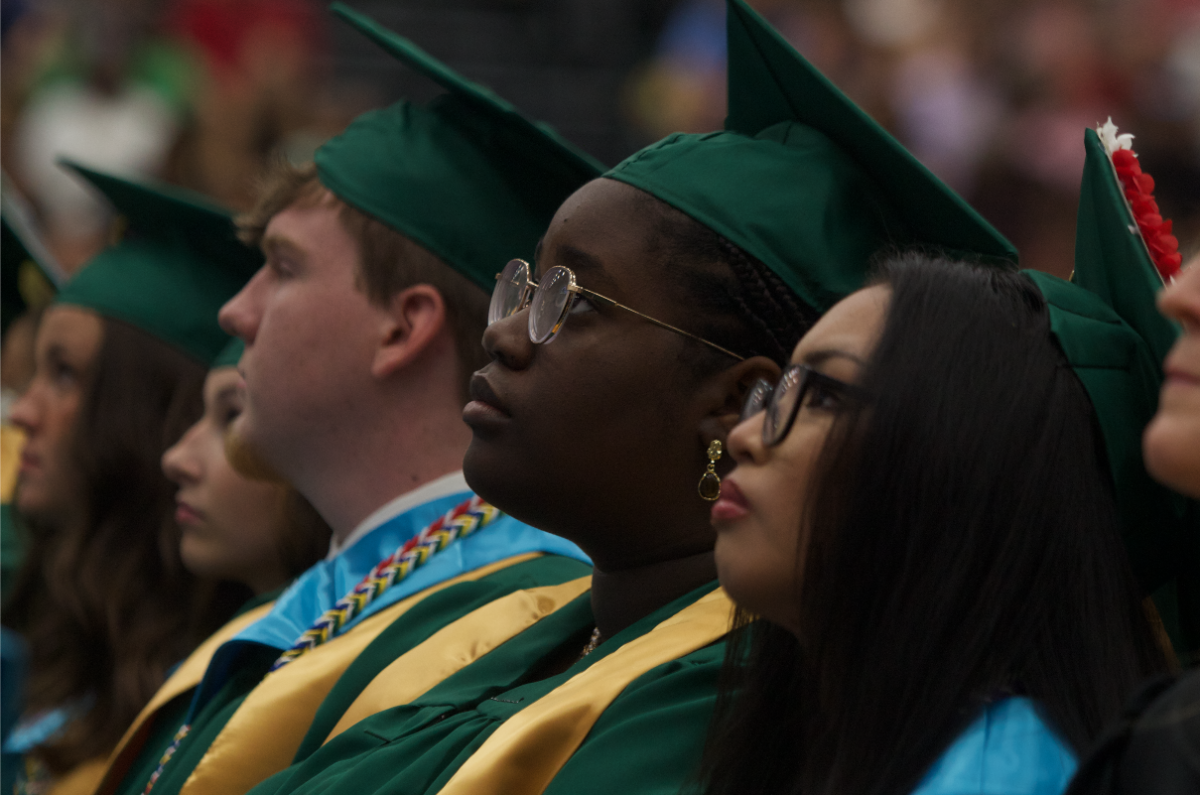 Graduates George Albertson, Tryphena Alaribe, and Anna Abing listen to the speeches of valedictorian and salutatorian. 