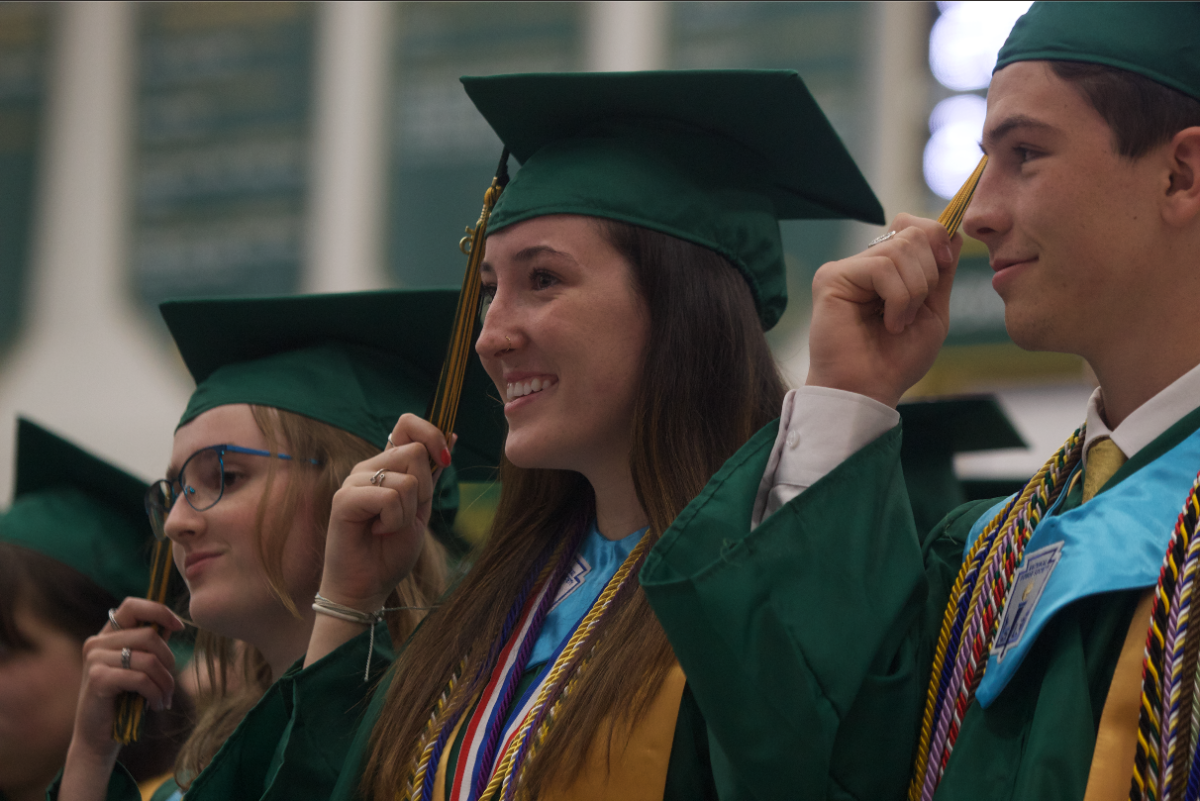 Graduates Luke Rowan, Brianna Mitchell, and Danielle Gordon hold their tassels before they are considered newly graduates.