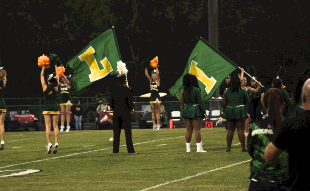 Cheer leads the football team out onto the field before the start of the game against Courtland.