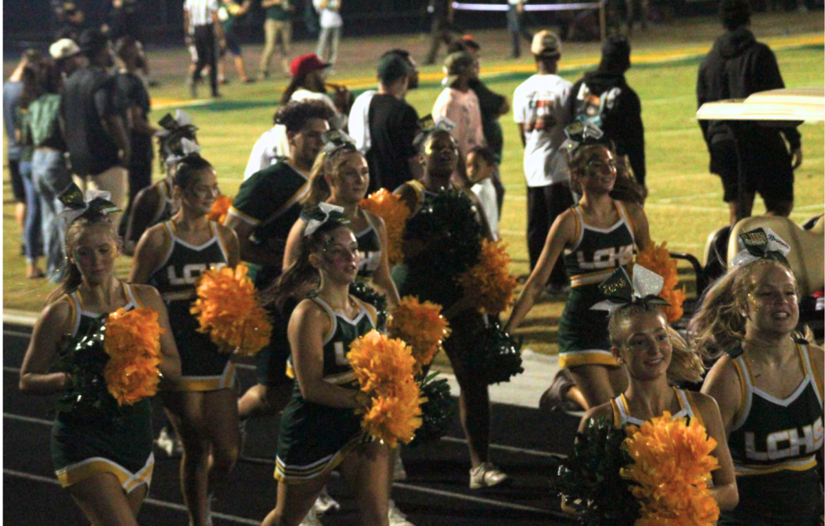 The cheerleaders  hustle back into their formation for the remainder of the game. 
