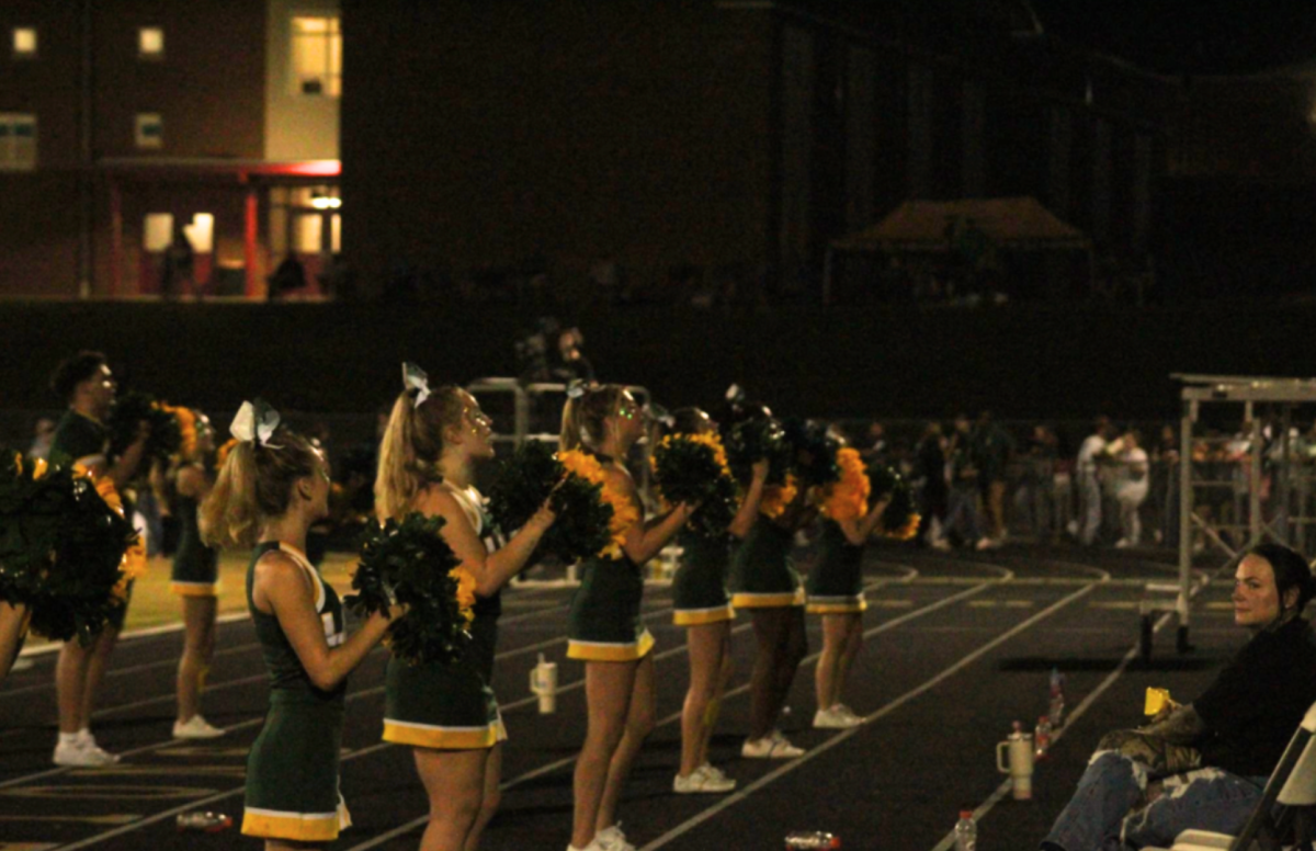 Coach Kelly Latham watches the team perform a cheer in the final minutes of the last quarter of the game.
