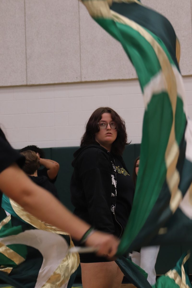 Senior Chloe Bomgardner watches her fellow color guard members during their pep rally routine.
