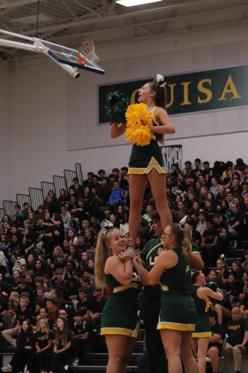 Cheerleaders perform their stunts to excite the audience and get students ready for the pep rally.