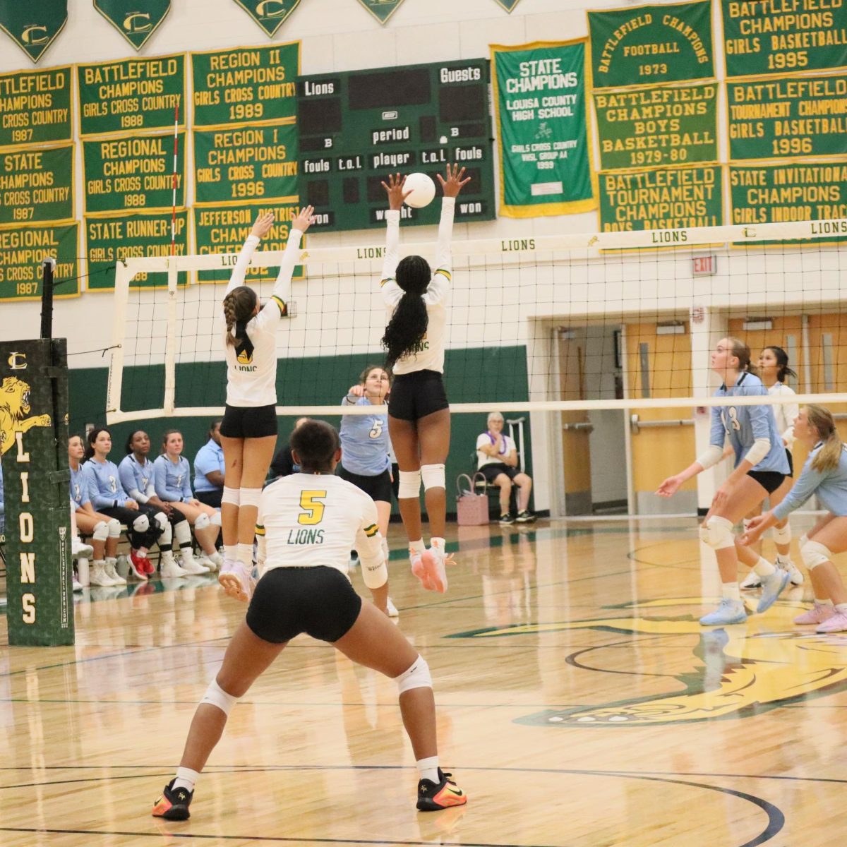 Senior Makayla Vest-Sims prepares to defend her side of the court, while her teammates try to block the incoming ball. 