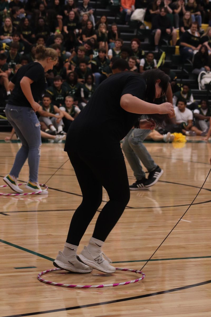 In this pep rally game, students race to the end as they try to keep their feet in the hoop.