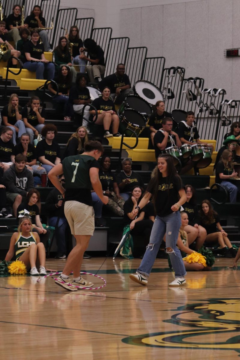 Senior Lily Hix leads senior Levi Wilson across the gym through a hoop to win the pep rally game.
