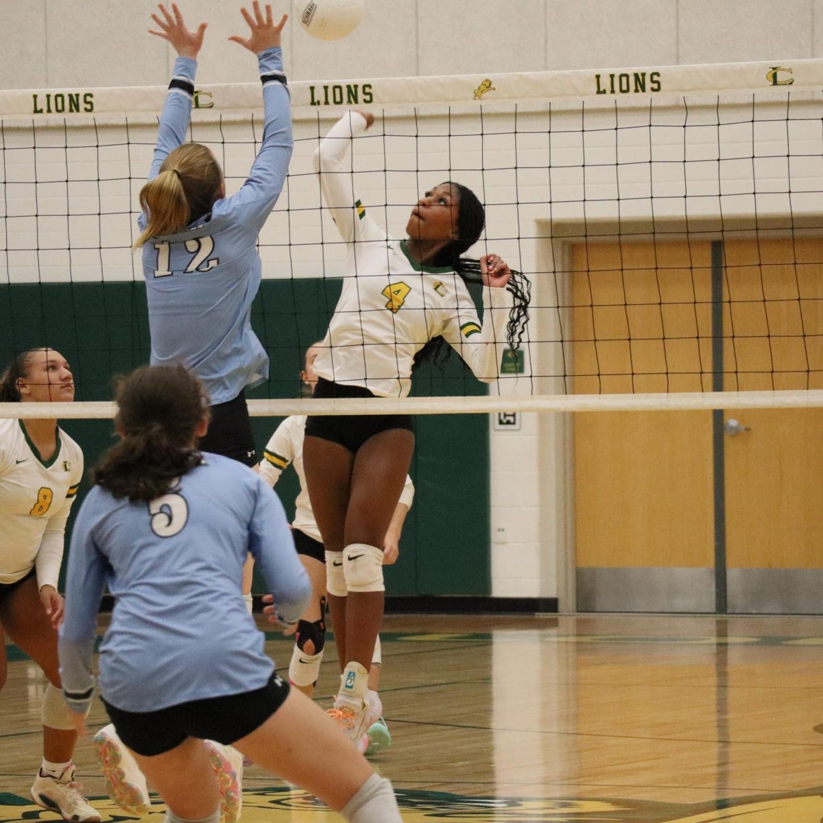 Williams spikes the ball over the net, while Green prepares for the rebound. 