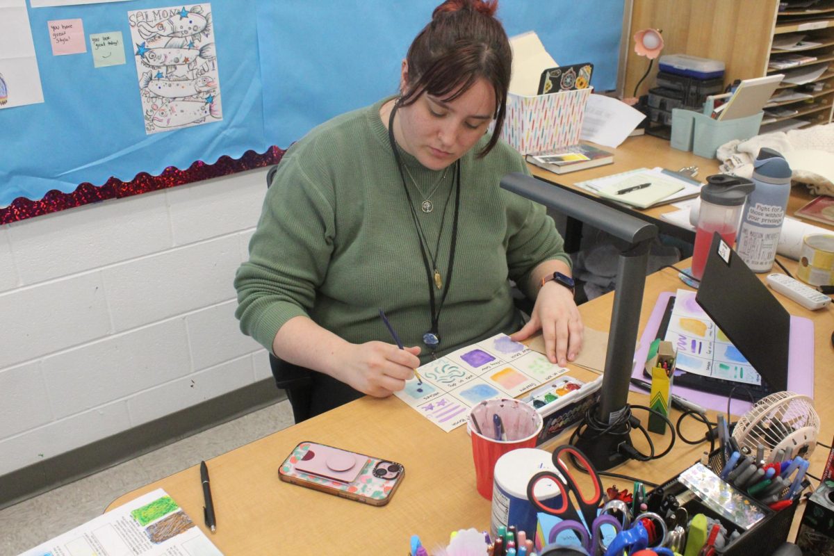 Art teacher Dani Perry shuts off her phone and concentrates on a watercolor practice worksheet.
