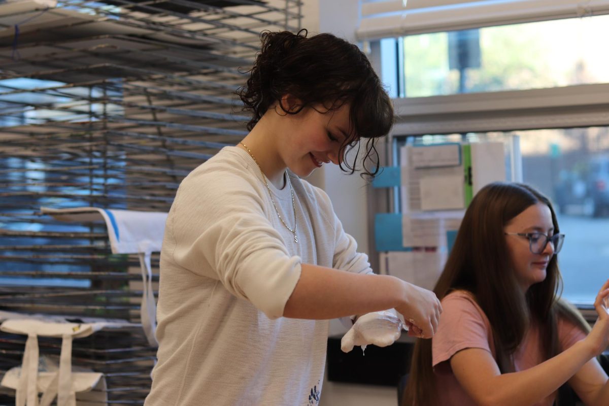 Solan Barger wraps her hand in plaster strips for the plaster hand project.
