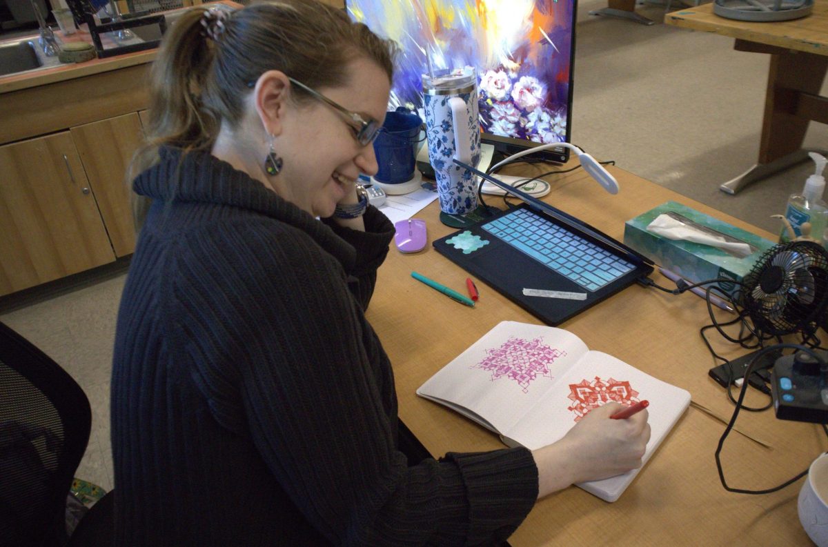 Alexandra LaBarr smiles as she draws different zentangles in her sketchbook designated for them.