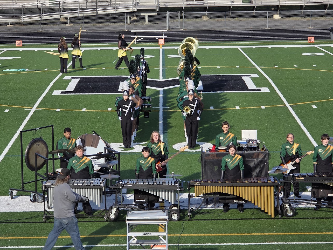 The marching band stands ready to perform at a competition.