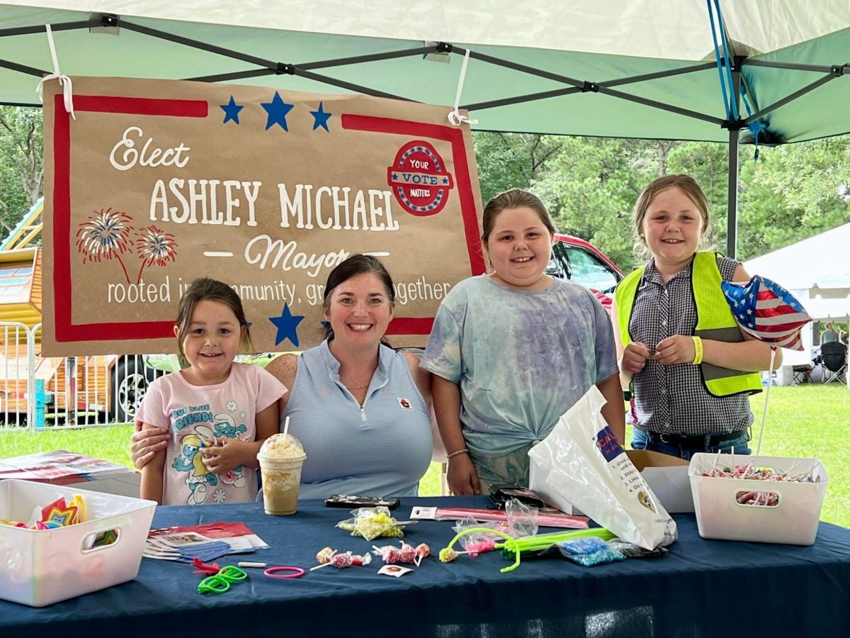 Town of Louisa Mayor, Ashley Michael, posing for a photo with family friends while at the Louisa County Ag Fair.