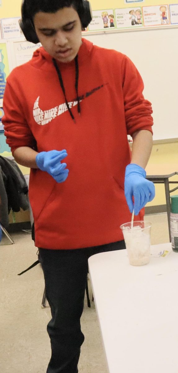 Sophomore Gabe Carter poring the sugar in the coffee cup.