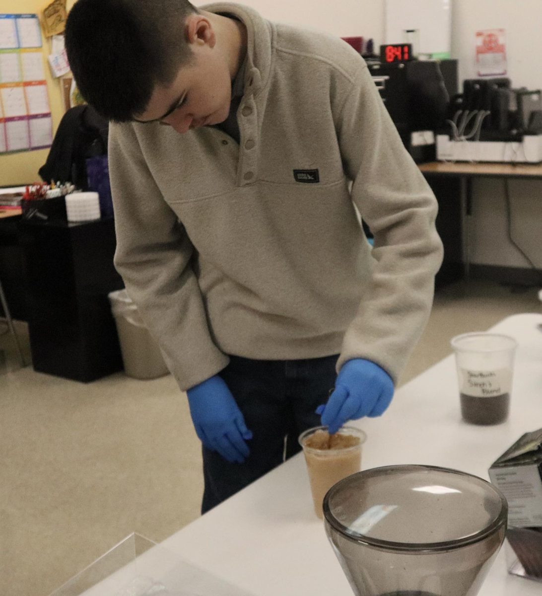 Freshman Jason Swingle stirs coffee to start the morning.