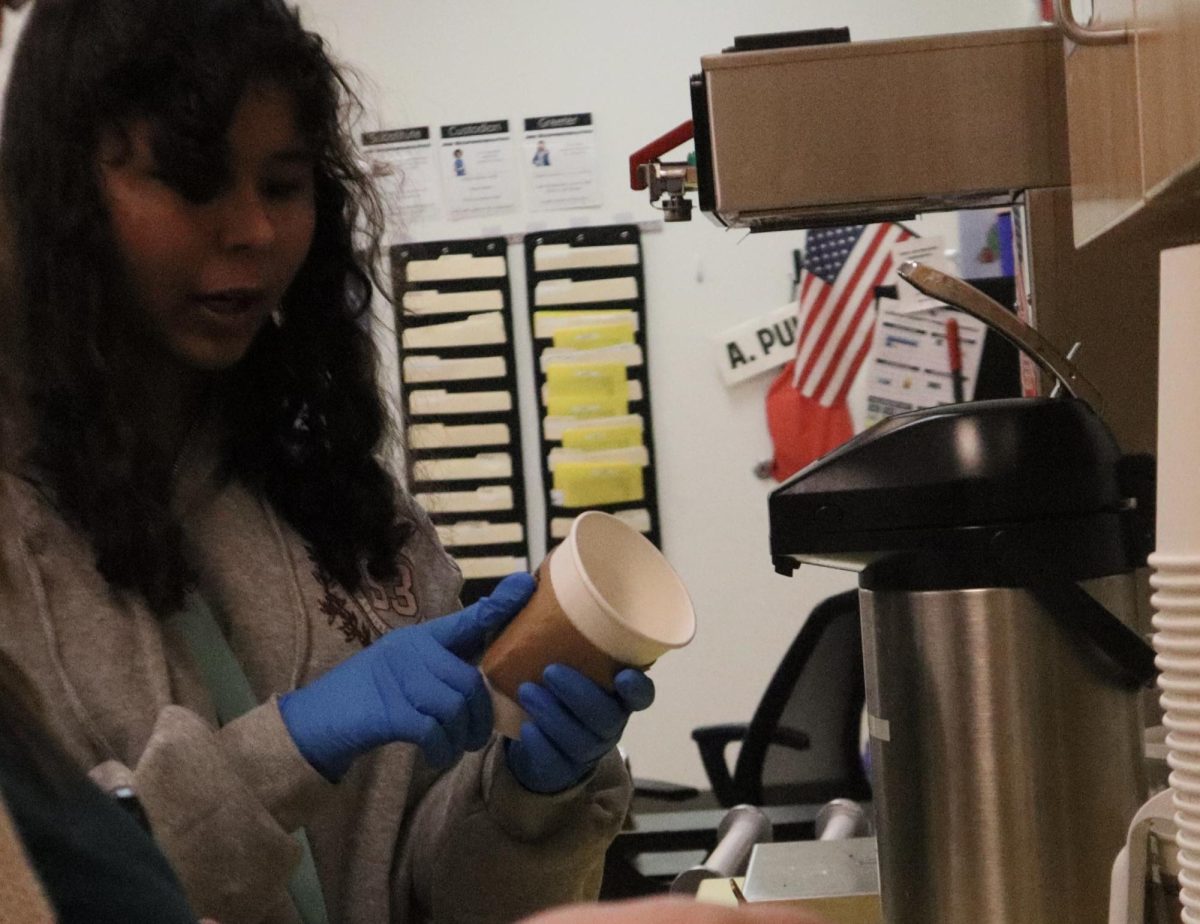 Freshman Haleigh Swingle reads what brew to make the coffee.