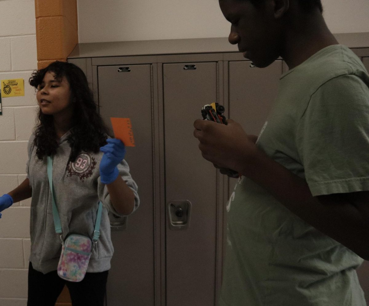 Freshman Hayleigh Williams giving a coffee card to Sophomore Gabriel Brooks