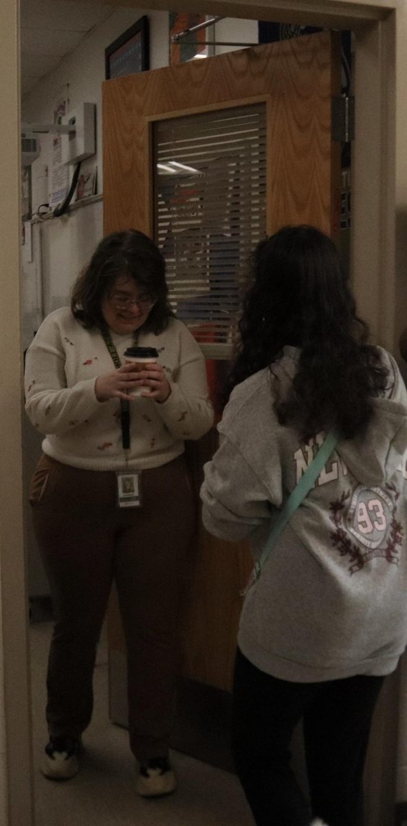 Freshman Aniyah Fleming gives Ms. Carr her coffee.