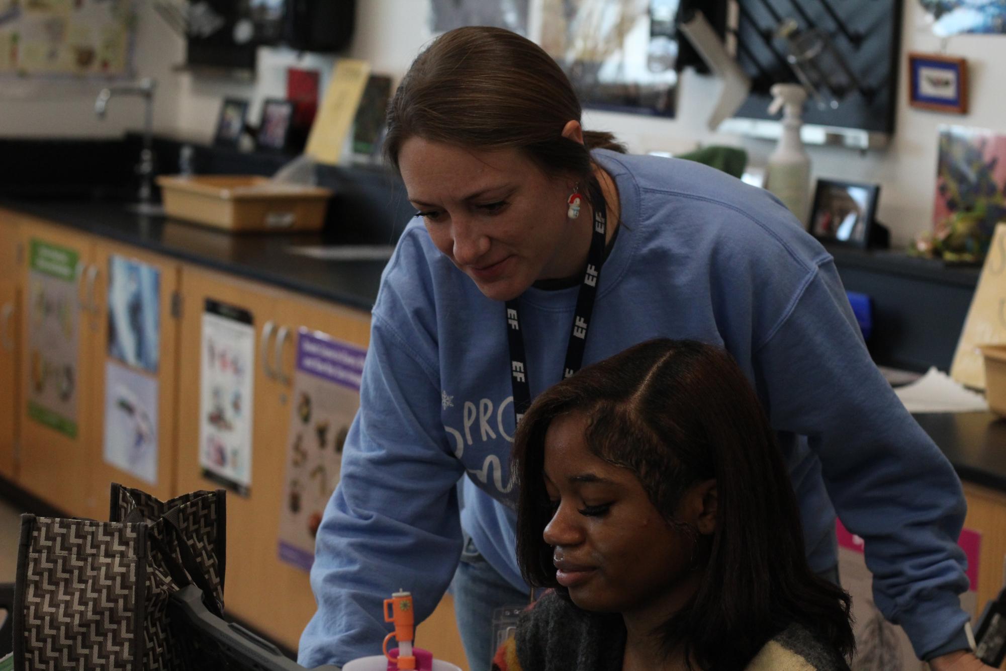 Jennifer Toney helping a student navigate her way through an assignment.