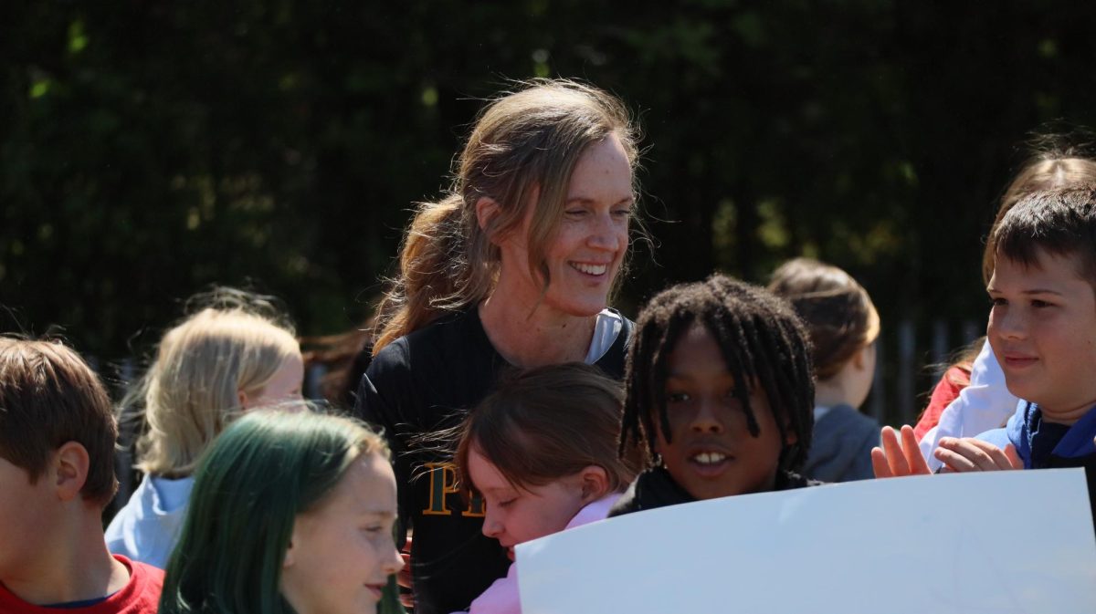 An elementary student embraces Ms.Fletcher after her run. 