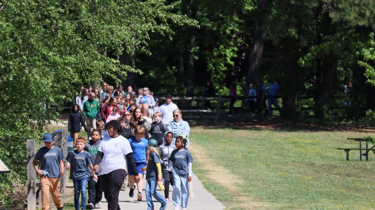 The elementary students exit their buses and make their way to the finish line to welcome Ms. Fletcher.