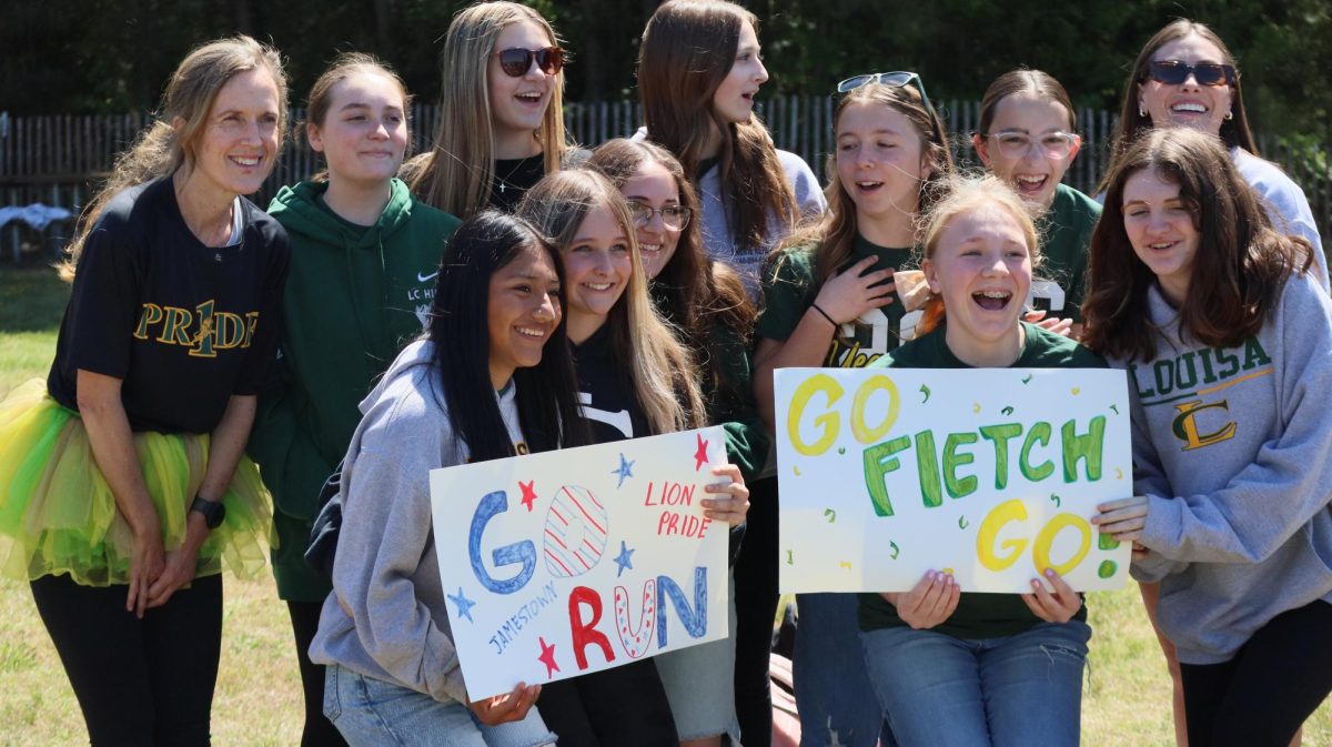 The middle school students stand together in order to get their photo taken with Ms. Fletcher.